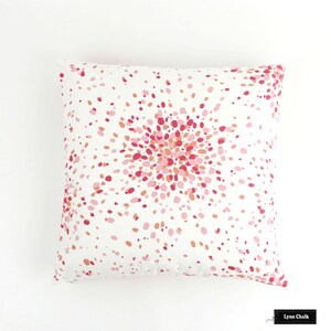 May include: White pillow with a pink and orange confetti pattern. The pattern is concentrated in the centre of the pillow, creating a burst effect.