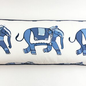 Puede incluir: Una almohada rectangular larga con fondo blanco y un patr&oacute;n repetido de elefantes azules. Los elefantes est&aacute;n decorados con detalles azules y blancos y caminan en l&iacute;nea.