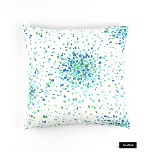 May include: White cushion with a blue and green confetti pattern. The pattern is concentrated in the centre of the cushion and spreads out towards the edges.