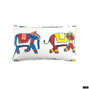 Puede incluir: Una almohada rectangular blanca con un estampado colorido de dos elefantes. Los elefantes est&aacute;n decorados con detalles rojos, amarillos, azules y verdes. La almohada es perfecta para a&ntilde;adir un toque de fantas&iacute;a a cualquier habitaci&oacute;n.