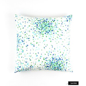 May include: A white cushion with a blue and green confetti pattern. The cushion is square and has a white background.