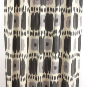 May include: Black and white patterned curtains with a geometric design. The curtains are made of a soft, woven fabric.
