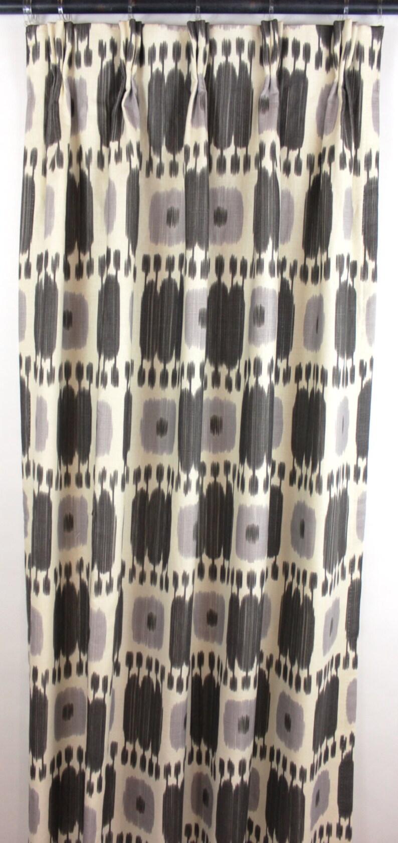 May include: Black and white patterned curtains with a geometric design. The curtains are made of a soft, woven fabric.