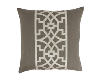 May include: A gray throw pillow with a white geometric pattern. The pattern is a repeating design of squares and circles.