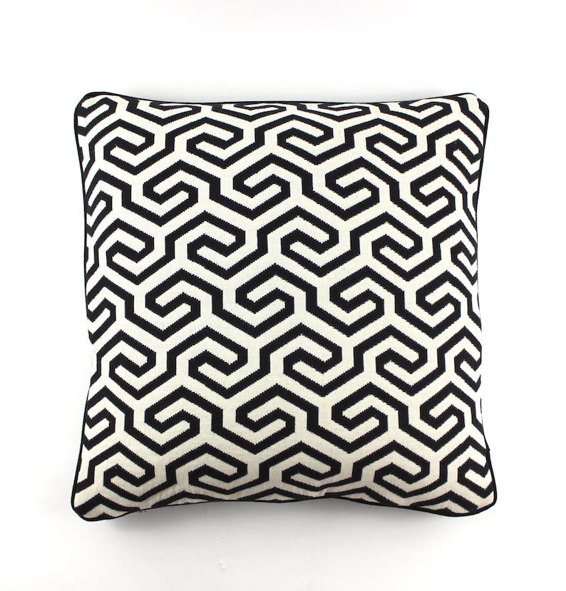 May include: Black and white geometric patterned throw pillow with a black border.