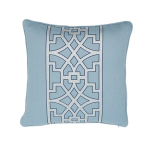 K&ouml;nnte beinhalten: Ein hellblaues Kissen mit einem wei&szlig;en und blauen geometrischen Muster. Das Muster ist ein sich wiederholendes Design aus Quadraten und Kreisen.