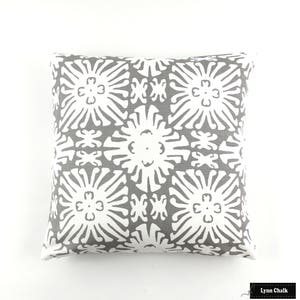 May include: Gray and white decorative pillow with a geometric pattern of stylized flowers.