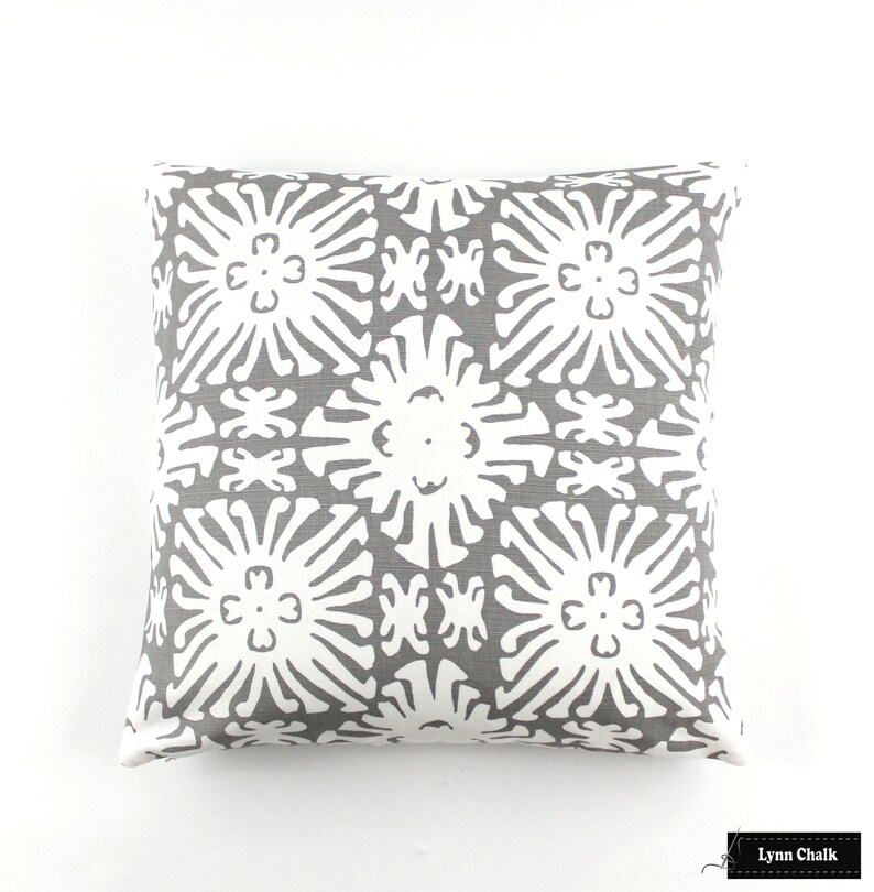 May include: Gray and white decorative pillow with a geometric pattern of stylized flowers.