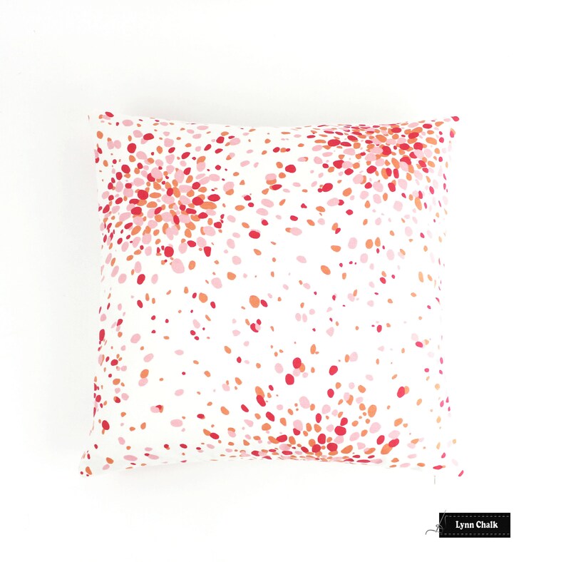 May include: White pillow cover with a pink, red and orange confetti pattern. The pattern is a burst of colour on a white background.