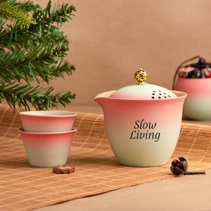 Puede incluir: Un juego de tres tazas de cerámica con un acabado moteado y mate. Las tazas son en tonos crema, gris claro y gris oscuro. Cada taza tiene un diseño simple y minimalista y un asa redondeada. Las tazas están apiladas una encima de la otra.