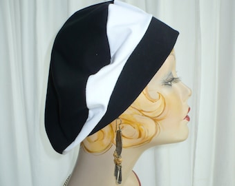 May include: A black and white striped beret with a white band around the crown. The beret is worn on a mannequin with a pearl necklace and dangle earrings.