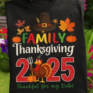 Könnte beinhalten: Schwarzes T-Shirt mit einem farbenfrohen Thanksgiving-Design. Das Design enthält die Worte "FAMILY Thanksgiving 25", Kürbisse, Herbstblätter und einen Cartoon-Truthahn, der eine Gabel hält. Der Text "Thankful for my tribe" ist ebenfalls enthalten.