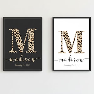 May include: Two framed prints featuring the name "Madison." One print has a black background with a leopard print "M" and gold text. The other print has a white background with a leopard print "M" and black text. Both prints include the date "January 15, 2025."