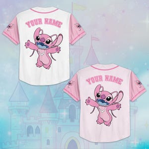 May include: Two baseball jerseys, one white and one pink, featuring a pink cartoon character with open arms. The white jersey has pink sleeves and trim, with "YOUR NAME" arched across the back. The pink jersey has white sleeves and trim.