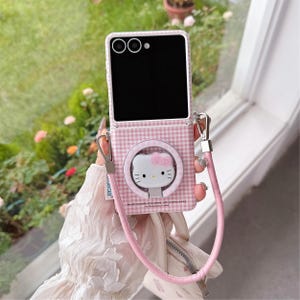 May include: Pink and white checked phone case with a Hello Kitty design. The case has a pink strap and silver hardware. The phone screen is black. The case has the text: "We will passionately love others, with sunshine shining for thousands of miles."