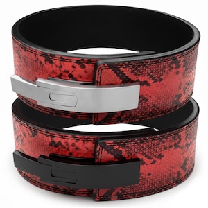 Puede incluir: Dos cinturones de halterofilia. Los cinturones son rojos con un estampado de piel de serpiente y ribete negro. Un cinturón tiene una hebilla plateada y el otro una hebilla negra. Los cinturones están diseñados para halterofilia y powerlifting.