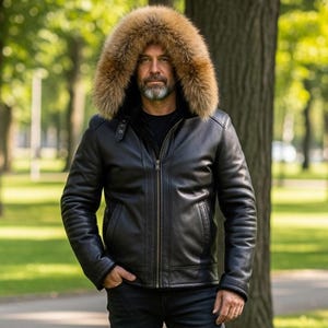 May include: A black leather jacket with a fur-lined hood. The jacket features a zip closure, side pockets, and quilted sleeves. The hood is trimmed with light brown fur. The person is wearing black jeans.