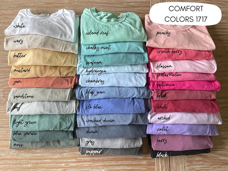 A collection of various colored t-shirts neatly stacked on top of each other, with each color labeled.