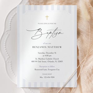 Op de afbeelding: Doopuitnodiging met een gouden kruis en scriptlettertype. De uitnodiging bevat de tekst "PLEASE JOIN US FOR THE Baptism of our son BENJAMIN MATTHEW" en evenementdetails. De achtergrond heeft lichtblauwe verticale strepen.
