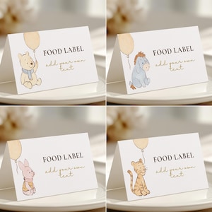 May include: Four white tent cards with illustrations of Winnie the Pooh characters. Each card has a different character: Winnie the Pooh, Eeyore, Piglet, and Tigger. The cards read "FOOD LABEL" and "add your own text" in gold.