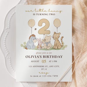 Może przedstawiać: Zaproszenie urodzinowe z napisem "our little hunny is turning two". Zaproszenie zawiera ilustracje postaci Kubusia Puchatka, dużą cyfrę 2 i balony. Zaproszenie jest na urodziny Olivii 05 sierpnia o godzinie 15:00.