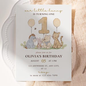 Puede incluir: Una invitación de cumpleaños color crema con el texto "our little hunny is turning one". La invitación presenta ilustraciones de personajes de Winnie the Pooh y el texto "OLIVIA'S BIRTHDAY" con fecha, hora y lugar.