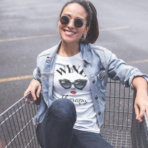 retro wine therapy tshirt with large cat eye sunglasses Wine Therapy Bella TShirt Retro Cat Eye Sunglasses Funny Wine Lover Tee Wine Mom Shirt Wine Gift for Her Vintage Wine Glamour Sunglasses Tee woman sitting in shopping cart wearing dark sunglasses