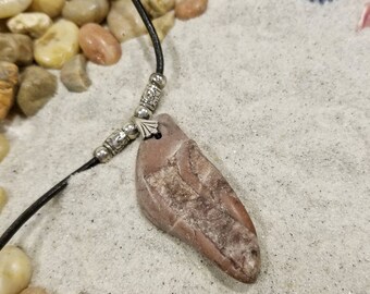 Pink stone pendant on leather cord w/sterling silver accents.