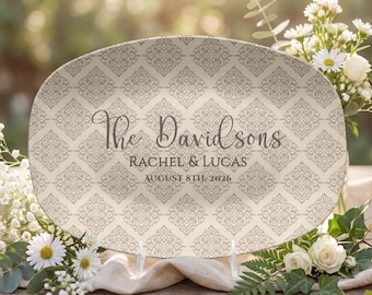 May include: Oval serving platter with a beige damask pattern. The platter features the text "The Davidsons", along with the names Rachel & Lucas and the date August 8th, 2026. The platter is displayed on a wooden surface with floral arrangements.