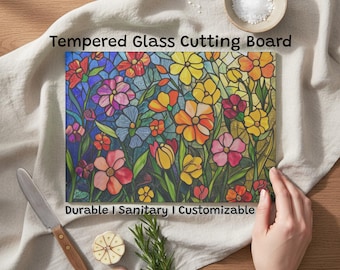 May include: Tempered glass cutting board with a vibrant floral design. The board showcases a stained-glass style pattern with flowers in red, pink, yellow, and orange hues. The text "Durable | Sanitary | Customizable" is printed on the board.
