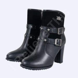 May include: Black leather ankle boots with a high heel. The boots feature studded straps and a suede panel at the top. Silver buckles and a zip are visible. A small emblem is on the side.