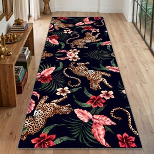 Peut inclure: Un long tapis rectangulaire avec un fond bleu foncé. Le tapis présente un motif répété d'animaux à imprimé léopard, de fleurs rouges et roses et de feuilles vertes. Le tapis est posé sur un sol en bois.