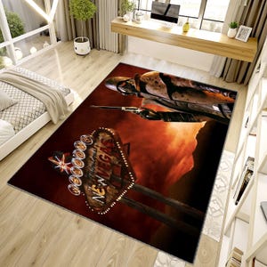 May include: A rectangular area rug featuring a dramatic scene with a figure holding a gun, and the iconic "Welcome to Fabulous Las Vegas" sign. The rug has a dark red and orange color scheme, with a distressed, vintage aesthetic.