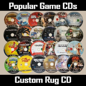 Puede incluir: Una colección de varios CD de juegos, incluyendo títulos como "Deadpool", "Sonic", "Harry Potter" y "Minecraft". Los discos están dispuestos en una cuadrícula, con el texto "Popular Game CDs" y "Custom Rug CD" en la parte superior e inferior.