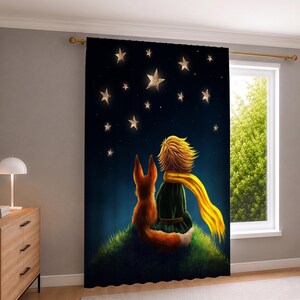 May include: A floor-length curtain panel featuring a dark blue night sky filled with glowing white stars. A small figure with blonde hair and a long yellow scarf sits on a grassy hill next to a fox, both looking up at the starry night sky.