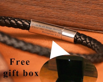 May include: Black braided leather bracelet with a silver clasp. The clasp is engraved with the text "I can do all things through Christ who strengthens me. Philippians 4:13." The bracelet is presented in a black gift box.