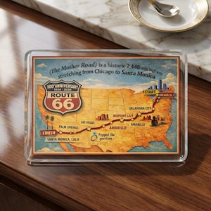 May include: A rectangular Route 66 souvenir with a map of the United States. The map highlights the historic 2,448-mile highway from Chicago to Santa Monica. The Route 66 logo is prominently displayed, with text indicating the 100th anniversary.