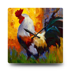 May include: Square wall clock with a colourful painting of a rooster. The artwork depicts a rooster with white, red, and orange feathers against a yellow and orange backdrop. Black clock hands show the time. The clock is a decorative item.
