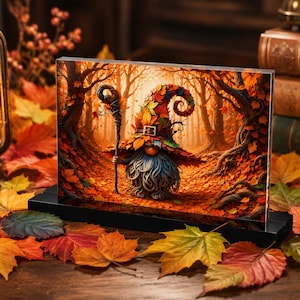May include: A rectangular acrylic block display featuring a vibrant illustration of a gnome with a long gray beard and a tall, curled hat covered in colorful autumn leaves, holding a wooden staff while standing in a forest filled with fall foliage.
