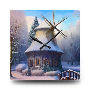 Könnte beinhalten: Quadratische Wanduhr mit einer Winterlandschaft mit einer schneebedeckten Windmühle, einer Brücke und Bäumen. Das Zifferblatt zeigt schwarze Zeiger vor dem Hintergrund. Die Windmühle hat einen Steinsockel und eine Holzspitze.