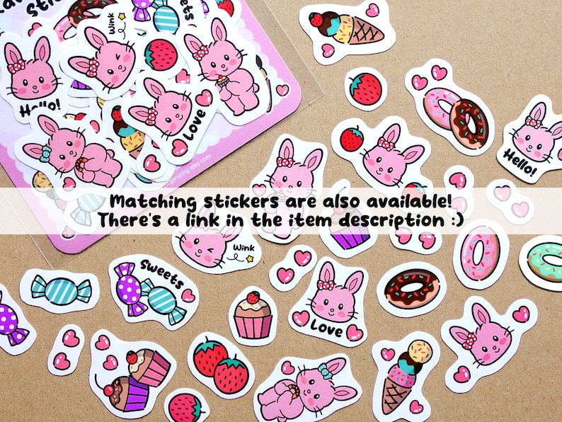 Op de afbeelding: Een vel met roze en witte stickers met schattige konijntjes, donuts, ijshoorns, cupcakes, snoepjes en hartjes. De stickers hebben zinnen zoals "Hallo!" en "Liefde" erop.