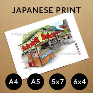 May include: A print labeled "JAPANESE PRINT" featuring a colorful illustration of a Japanese street food stall with red and yellow signage. The print includes the text "Cute Organizing" and is available in A4, A5, 5x7, and 6x4 sizes.