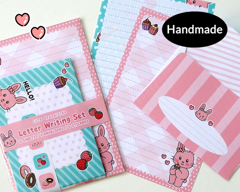 Op de afbeelding: Een set roze en blauwe briefpapier met een schattig konijnenontwerp. De set bevat 8 vellen briefpapier, 4 enveloppen en 4 stickers. De tekst op de verpakking luidt "Cute Organizing Letter Writing Set 8 Sheets / 4 Envelopes / 4 Stickers".
