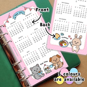 May include: Pink 2026 calendar inserts with monthly layouts, featuring cute illustrations of a bunny, cat, and dog. The back side has a breakfast theme. Text includes "Tea time" and "5 colours are available."