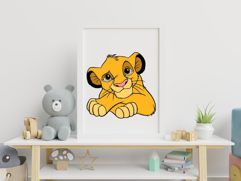 May include: A framed print featuring a cartoon illustration of a yellow lion cub with a pink nose and black accents. The artwork is displayed on a white shelf with toys and decorative items.
