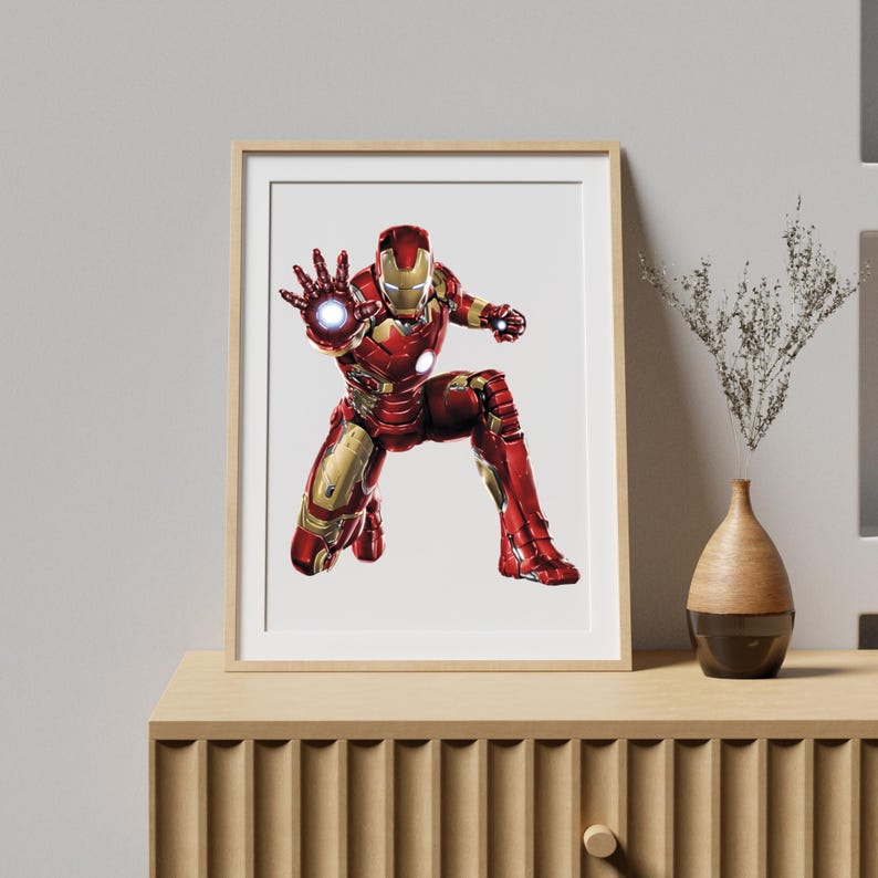 Pu&ograve; includere: Stampa incorniciata con Iron Man in una posa dinamica, vestito con un'armatura rossa e dorata. L'opera raffigura il supereroe in ginocchio con una mano tesa, che emette un'esplosione di energia brillante. La stampa &egrave; esposta in una cornice di legno.