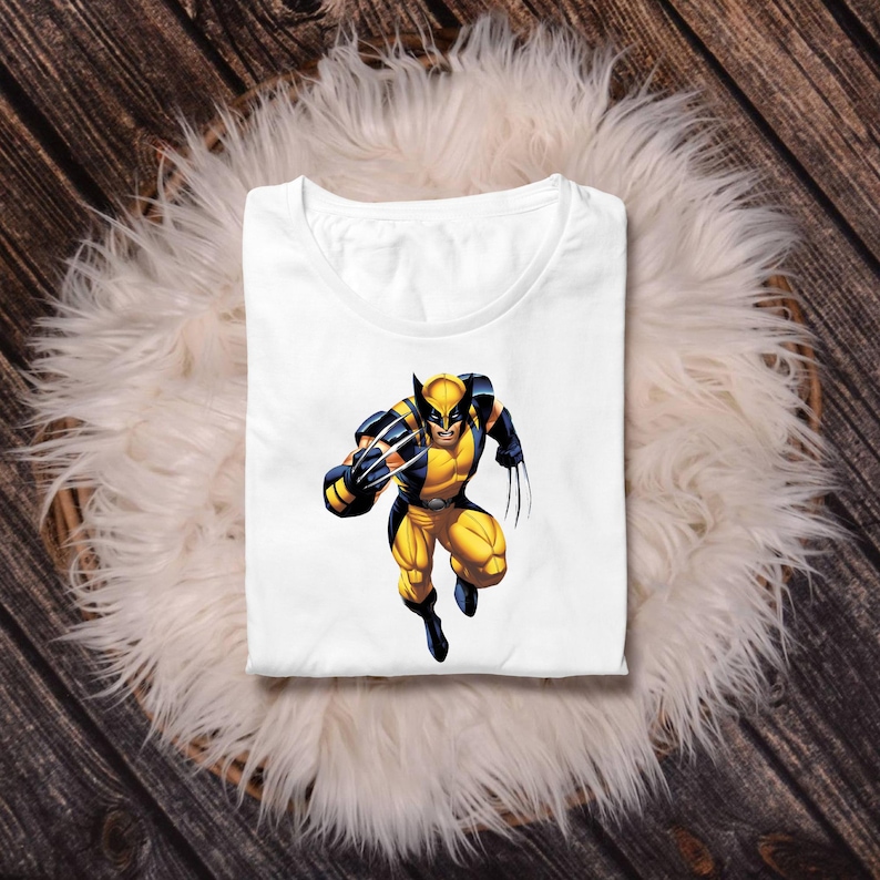 Pu&ograve; includere: T-shirt bianco con grafica a colori di Wolverine nel suo costume giallo e blu. Il supereroe &egrave; raffigurato in una posa dinamica, con gli artigli estesi. La maglietta &egrave; piegata e appoggiata su una superficie bianca e soffice.