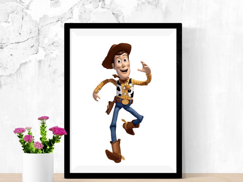 May include: A framed print featuring the character Woody from the animated film Toy Story. Woody is depicted in his signature cowboy attire, including a brown hat, yellow plaid shirt, and blue jeans. The image is set against a white background.