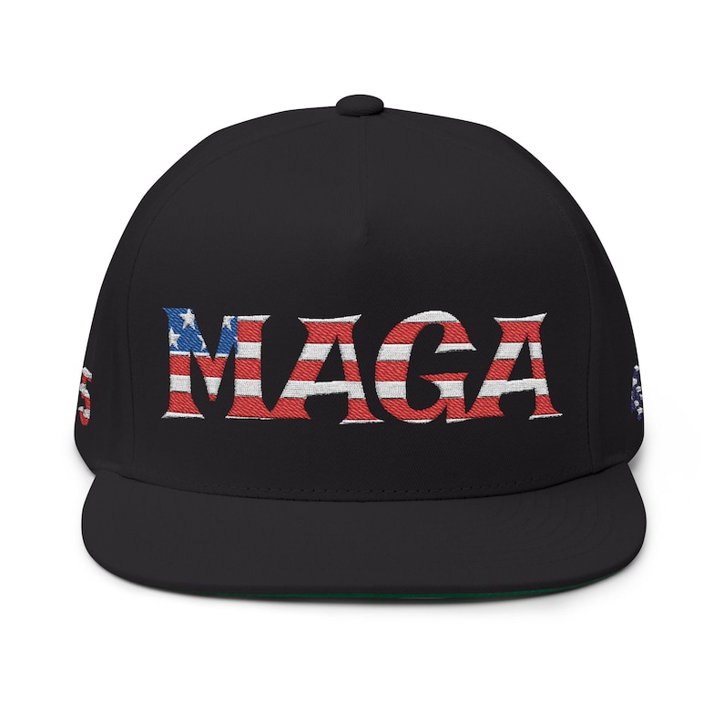 Może przedstawiać: Czarna czapka z daszkiem z płaskim daszkiem, z wyhaftowanym słowem "MAGA" w kolorze czerwonym, białym i niebieskim, stylizowanym na amerykańską flagę. Czapka ma zielony sp&oacute;d i guzik na g&oacute;rze. Mała amerykańska flaga znajduje się z boku.