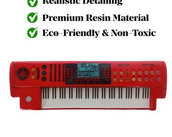 May include: A red toy keyboard with white keys and a digital display. The keyboard has buttons and knobs, with the text "MELODI" and "RHYTHM" visible. The image also includes text that reads "Realistic Detailing", "Premium Resin Material", and "Eco-Friendly & Non-Toxic".